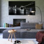 Modern gray living room featuring a fireplace and cityscape artwork, creating a cozy ambiance.